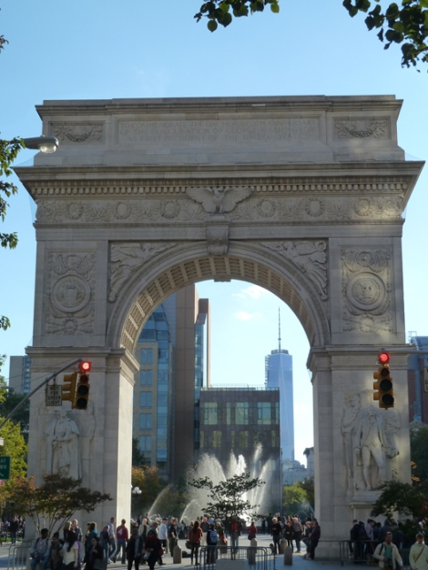 The still-under-constrution One World Trade Center can be seen in the distance through the Washington Square Arch.